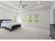 A primary bedroom featuring lots of natural light, three windows, and carpeted floors at 779 Keystone Dr, Woodstock, GA 30188