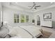 Spacious main bedroom with a tray ceiling, fan, large windows, and a view into the adjoining main bath at 779 Keystone Dr, Woodstock, GA 30188