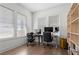 An office space with two desk spaces, shelving, multiple windows, and hardwood floors at 779 Keystone Dr, Woodstock, GA 30188