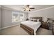 Relaxing bedroom has a queen-sized bed, ceiling fan, and neutral carpet at 1008 Knoxboro Ln, Woodstock, GA 30188