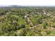Expansive aerial view captures a neighborhood surrounded by mature trees, with mountains visible at 1755 Pinetree Pass Sw Ln, Lilburn, GA 30047