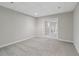 Finished basement with neutral walls, plush carpeting, and a set of double doors at 1755 Pinetree Pass Sw Ln, Lilburn, GA 30047