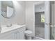 Neutral powder room featuring a stylish vanity, toilet, and doorway to an adjacent room at 1755 Pinetree Pass Sw Ln, Lilburn, GA 30047