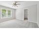 This bedroom has plush carpet, a ceiling fan, and a double window at 1755 Pinetree Pass Sw Ln, Lilburn, GA 30047