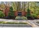 Inviting entrance to Evergreen Crossing with brick signage, manicured shrubs and decorative plants at 1755 Pinetree Pass Sw Ln, Lilburn, GA 30047