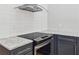 Close-up of kitchen cooktop with granite countertops and modern stainless range hood at 1755 Pinetree Pass Sw Ln, Lilburn, GA 30047
