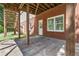 Covered patio area with brick wall, support beams, and an entrance door at 1755 Pinetree Pass Sw Ln, Lilburn, GA 30047