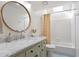 A well-lit bathroom with marble counters, white cabinets, and a shower over tub at 4086 Norton Se Pl, Smyrna, GA 30082
