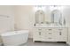 Bright bathroom with double vanity, modern mirrors, stylish fixtures, and a separate soaking tub at 4086 Norton Se Pl, Smyrna, GA 30082