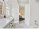 Bathroom featuring bright white tiles, modern fixtures, and an open doorway that leads to a cozy bedroom space at 4086 Norton Se Pl, Smyrna, GA 30082
