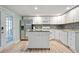 Modern kitchen with stainless steel appliances, white cabinets, kitchen island with seating, and wood flooring at 4086 Norton Se Pl, Smyrna, GA 30082