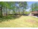 Spacious backyard with large trees and access to the brick patio and fireplace at 4095 Boles Creek Dr, Duluth, GA 30096