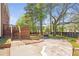 Landscaped backyard with a wooden deck, lush trees, and a view of the house at 4095 Boles Creek Dr, Duluth, GA 30096