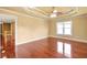 Bedroom showcasing tray ceiling, windows, and hardwood floors at 4095 Boles Creek Dr, Duluth, GA 30096