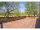 Large wooden deck with decorative railings, providing an excellent view of the backyard and trees at 4095 Boles Creek Dr, Duluth, GA 30096