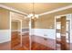 Hardwood floor dining room with an ornate light fixture and passage ways to other rooms at 4095 Boles Creek Dr, Duluth, GA 30096