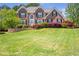 Charming two-story brick home with lush lawn, mature trees, and beautiful landscaping at 4095 Boles Creek Dr, Duluth, GA 30096