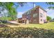 View of the home's brick exterior with a back patio and fireplace, seen from the expansive backyard at 4095 Boles Creek Dr, Duluth, GA 30096