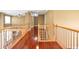 Upstairs hall featuring hardwood floors and a wooden railing overlooking the floor below at 4095 Boles Creek Dr, Duluth, GA 30096