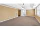 Spacious carpeted living room featuring modern lighting and neutral wall colors at 4095 Boles Creek Dr, Duluth, GA 30096