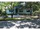 Charming exterior view of a light blue home featuring a well maintained yard and ample trees at 5048 Westbrook Rd, Union City, GA 30291