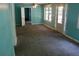 Bright living room featuring turquoise walls, carpet, ceiling fan and double doors to the outside at 5048 Westbrook Rd, Union City, GA 30291