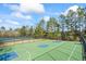 Outdoor basketball court featuring a green surface with blue accents, surrounded by trees and fencing at 75 Glen Abbey Cir, Fairburn, GA 30213