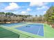 Well-maintained tennis courts featuring a blue surface with green out-of-bounds areas, surrounded by trees at 75 Glen Abbey Cir, Fairburn, GA 30213