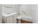 This bathroom features a bathtub, white tile, and a vanity with a sink and cabinet at 8554 Taylor Rd, Riverdale, GA 30274