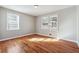 This bedroom offers hardwood floors, light-colored walls, and two windows for natural light at 8554 Taylor Rd, Riverdale, GA 30274