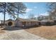 Brick home with a concrete driveway and mature trees on a sunny day at 8554 Taylor Rd, Riverdale, GA 30274