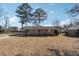 Quaint brick home with mature trees and a long driveway on a sunny day at 8554 Taylor Rd, Riverdale, GA 30274