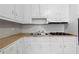 White cabinets, a stainless steel sink, and a four-burner gas cooktop highlight the kitchen at 8554 Taylor Rd, Riverdale, GA 30274