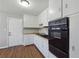 The kitchen boasts wood-look floors, white cabinets, a stainless steel sink, and an oven at 8554 Taylor Rd, Riverdale, GA 30274