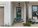 Close up of an inviting blue front door with wreath and brick pathway and an outdoor seating area at 228 Idylwilde Way, Canton, GA 30115