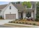 Inviting home with a two-car garage, covered porch, and blooming flowers in the front yard at 228 Idylwilde Way, Canton, GA 30115