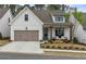 Charming cottage-style home with a two-car garage, covered porch, and well-maintained landscaping at 228 Idylwilde Way, Canton, GA 30115