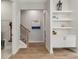 Hallway features built-in shelving, wood floors, and staircase with modern railing at 228 Idylwilde Way, Canton, GA 30115