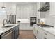 Well-lit kitchen showcasing white cabinets, stainless steel appliances, and an island with marble countertops at 228 Idylwilde Way, Canton, GA 30115