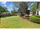 Expansive backyard featuring lush green grass, mature trees, a wooden fence, and a small playhouse at 4070 Amber Leaf Dr, Roswell, GA 30076