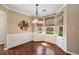 Bright breakfast nook featuring hardwood floors, natural light from bay windows, and elegant light fixture at 4070 Amber Leaf Dr, Roswell, GA 30076