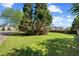 Spacious front yard featuring lush green grass and mature trees on a sunny day at 4070 Amber Leaf Dr, Roswell, GA 30076