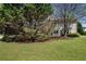 Manicured lawn and lush landscaping featuring mature trees and a partial view of the house at 4070 Amber Leaf Dr, Roswell, GA 30076