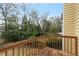 View of the backyard from the wooden balcony of this yellow house, overlooking lush trees at 873 Monroe Ne Cir, Atlanta, GA 30308