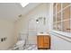 Bright bathroom with a skylight, window, oak vanity and checkered floors at 873 Monroe Ne Cir, Atlanta, GA 30308