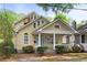 Charming yellow two-story home with a porch swing, red and green landscaping, and unique architectural features at 873 Monroe Ne Cir, Atlanta, GA 30308