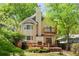 Charming two-story home featuring a wooden deck, balcony, light yellow exterior, and a chimney amid lush greenery at 873 Monroe Ne Cir, Atlanta, GA 30308