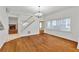Open-concept living room with hardwood floors, white walls, large windows, and a cozy fireplace visible at 873 Monroe Ne Cir, Atlanta, GA 30308