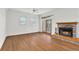 Spacious living room featuring a brick fireplace, hardwood floors, and natural light from windows and glass doors at 873 Monroe Ne Cir, Atlanta, GA 30308