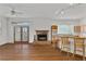 Open-concept living room with a fireplace, counter seating, hardwood floors, and a backyard view at 873 Monroe Ne Cir, Atlanta, GA 30308